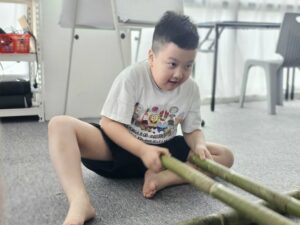 Students practicing teamwork and rhythm in the Bamboo Dance