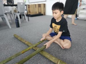 Students practicing teamwork and rhythm in the Bamboo Dance